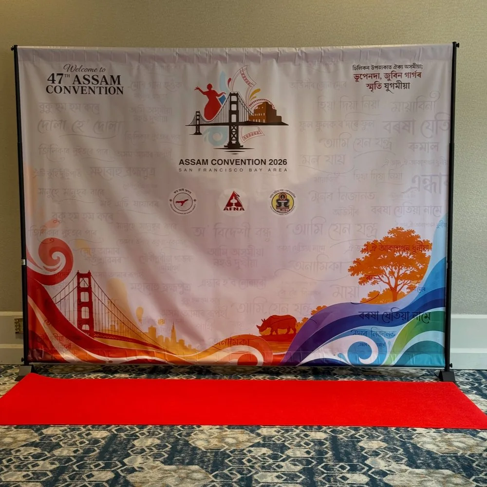 Assam Convention printed backdrop on a stand above a red carpet