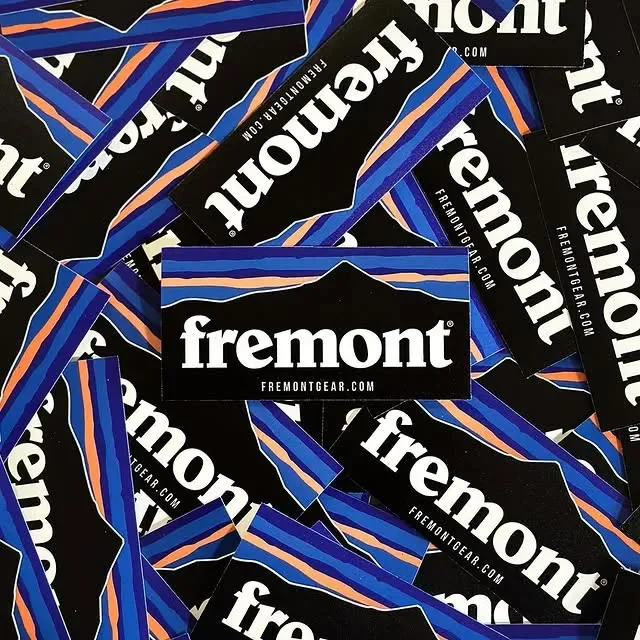 Pile of black and blue Fremont Gear die-cut stickers