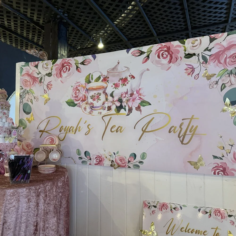 A floral printed party backdrop installed behind a dessert table