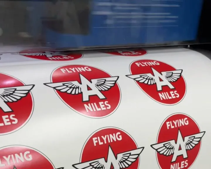 Red Flying A Niles round labels feeding out of the printer