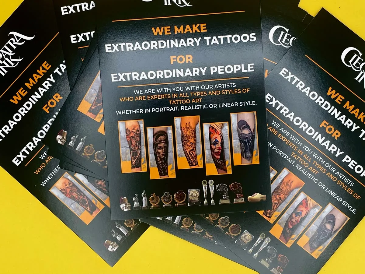 Fanned Cleopatra Ink tattoo flyers on yellow