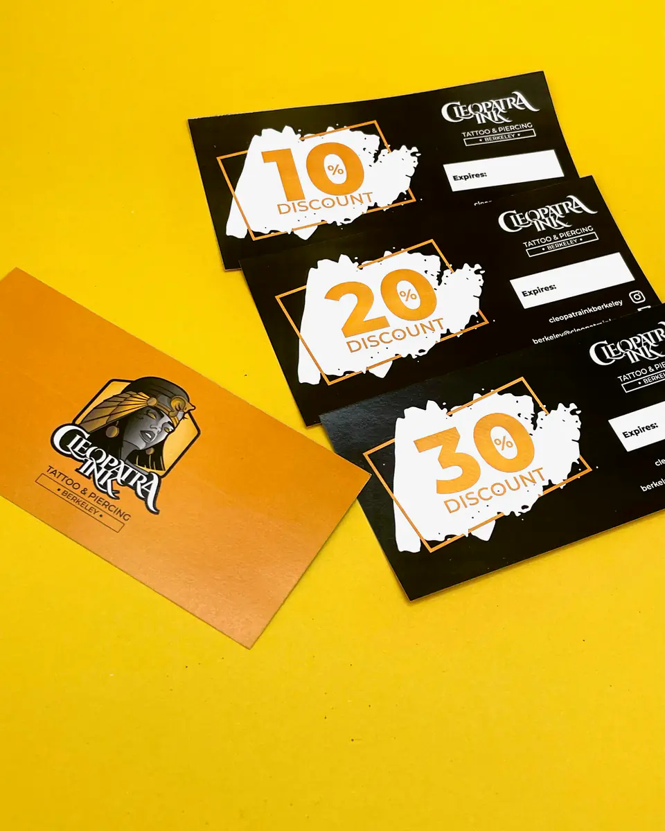 Cleopatra Ink 10, 20 and 30 percent discount cards with a business card on yellow
