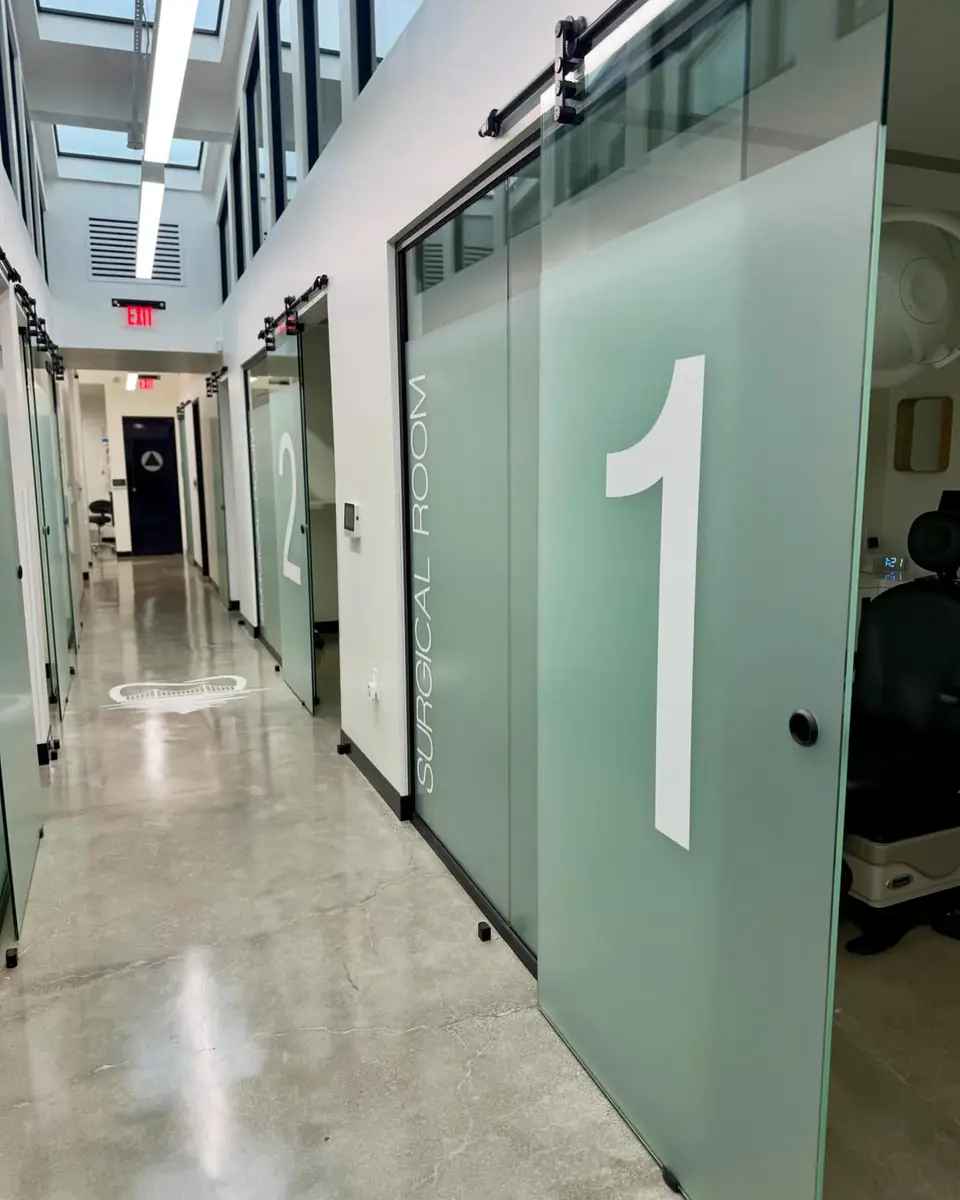 Frosted glass door with a large cut vinyl number 1 in a dental office hallway